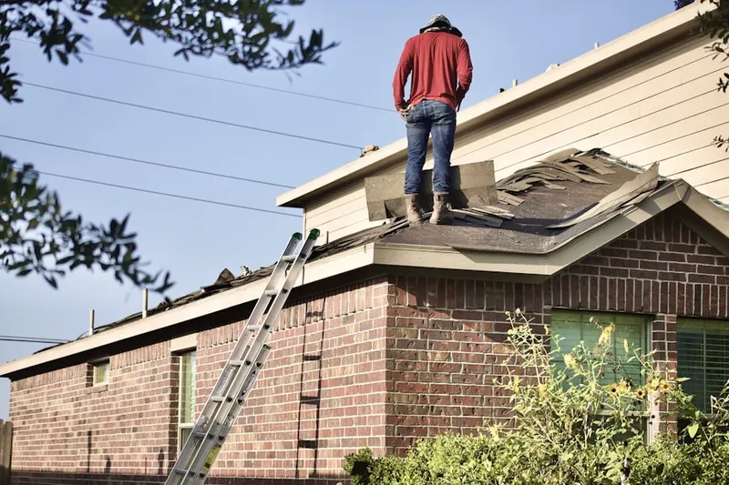 Professional roofer working on a residential roof in Parish Center